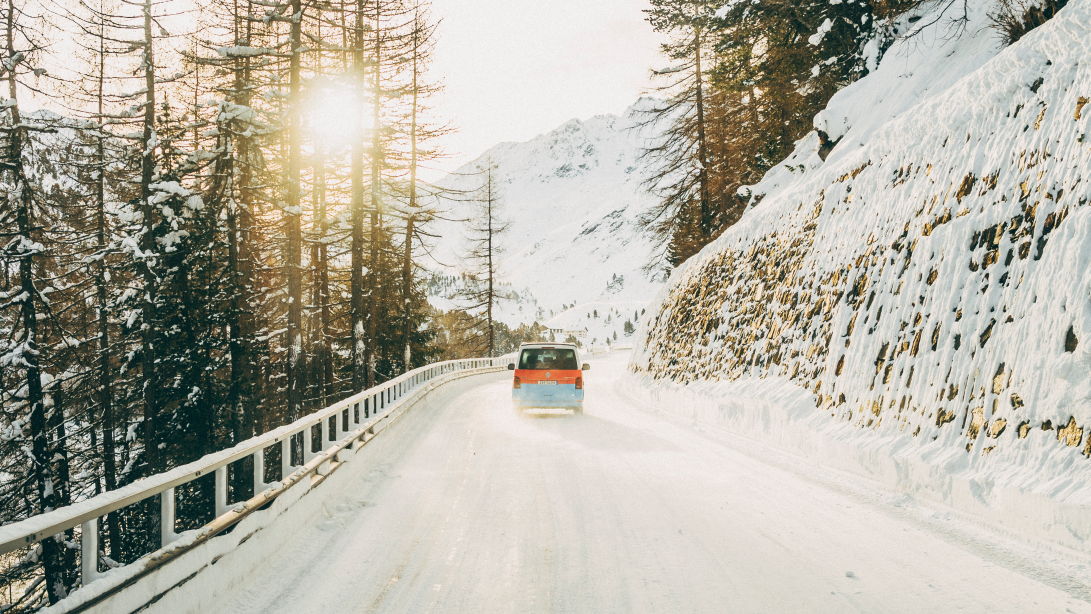 Ein Volkswagen Nutzfahrzeug fährt eine winterliche Straße entlang