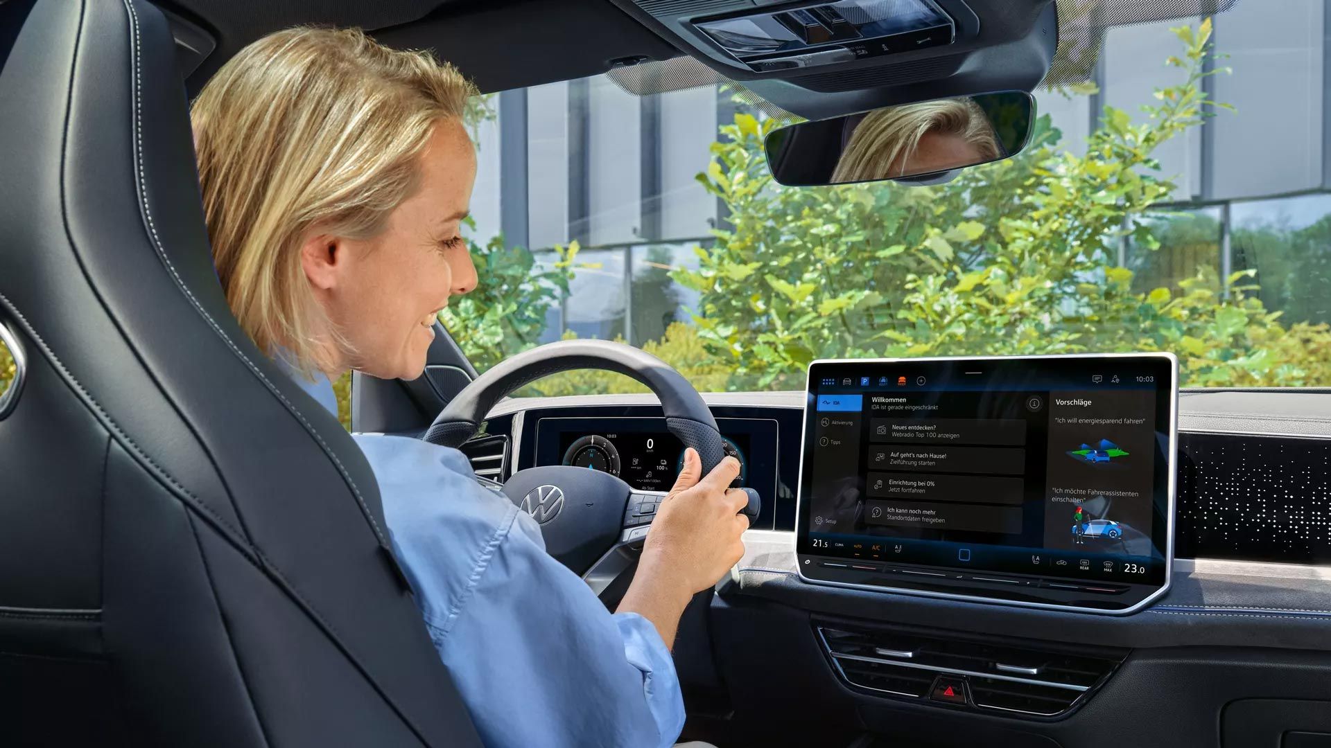 Eine Frau sitzt im VW Passat und blickt auf das Infotainmentsystem