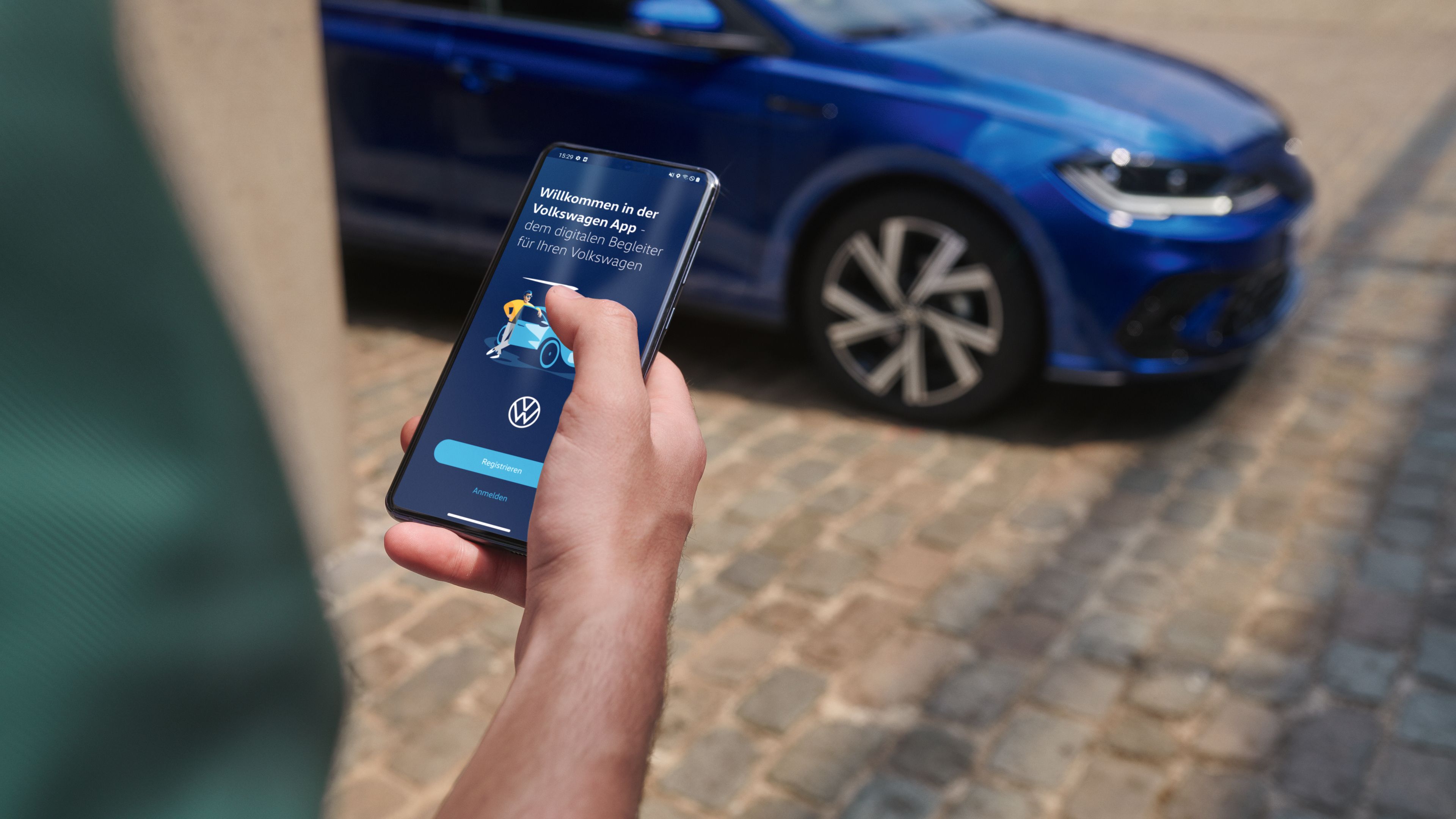 Person nutzt die Volkswagen App auf dem Smartphone, im Hintergrund ein blauer Polo R-Line