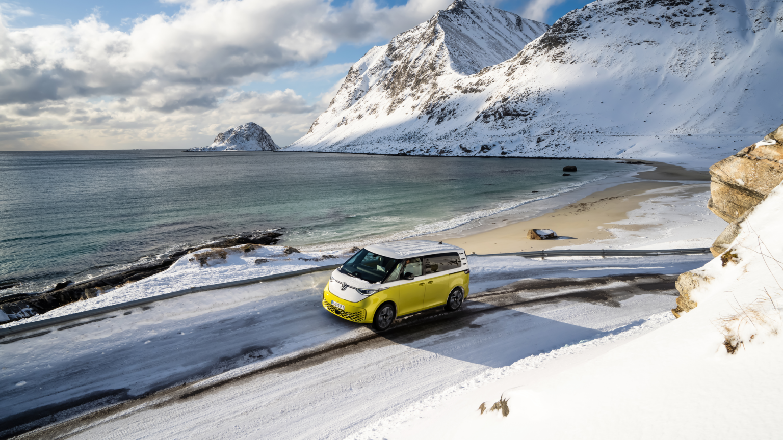 In Volkswagen ID. Buzz fährt auf einer winterlichen Strasse am Meer