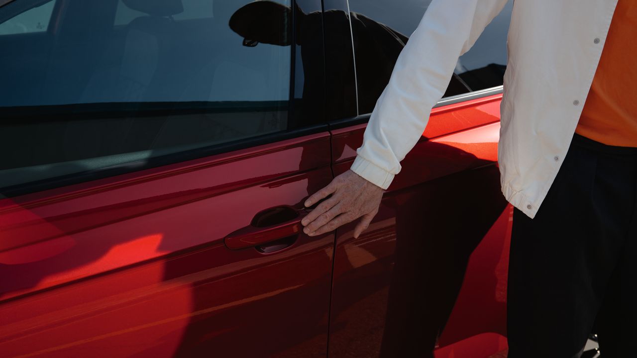 Mann nutzt Keyless Access um seinen roten VW Taigo zu entriegeln