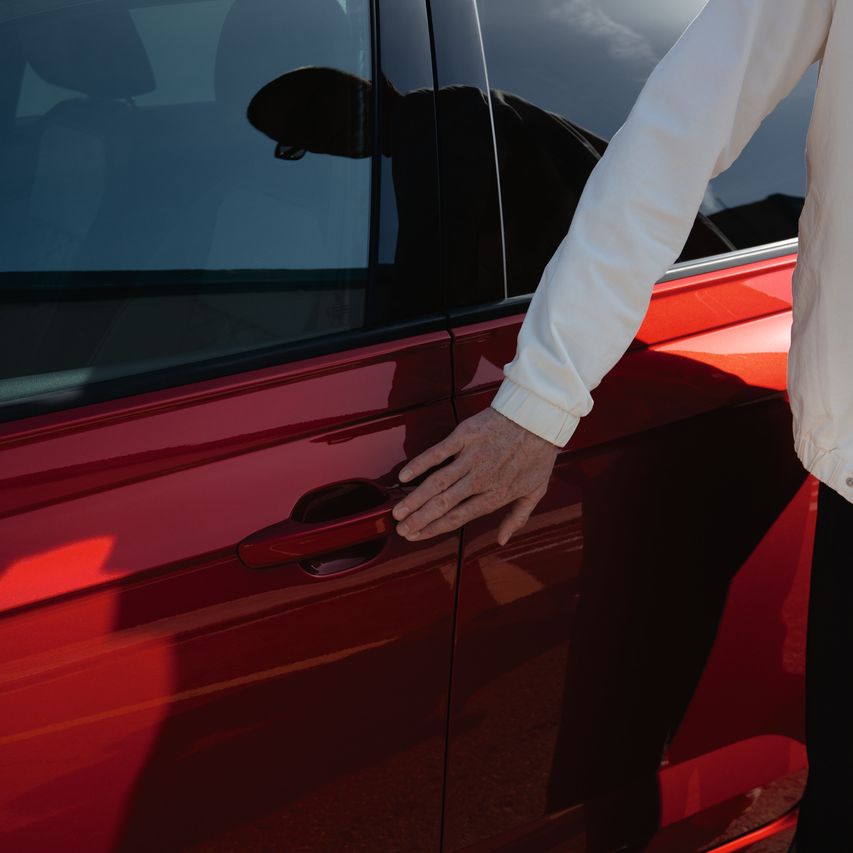 Mann nutzt Keyless Access um seinen roten VW Taigo zu entriegeln