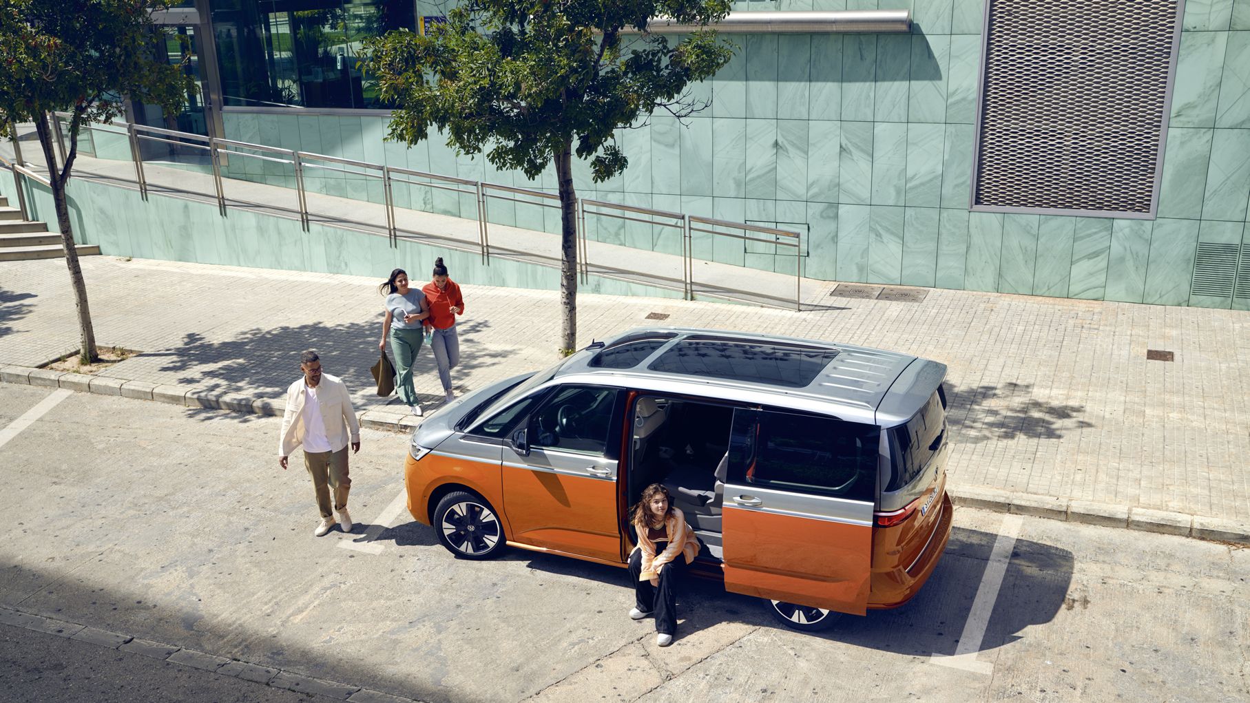 Der neue VW Multivan T7 2021 Energetic steht mit geöffneter Schiebetür am Ufer.