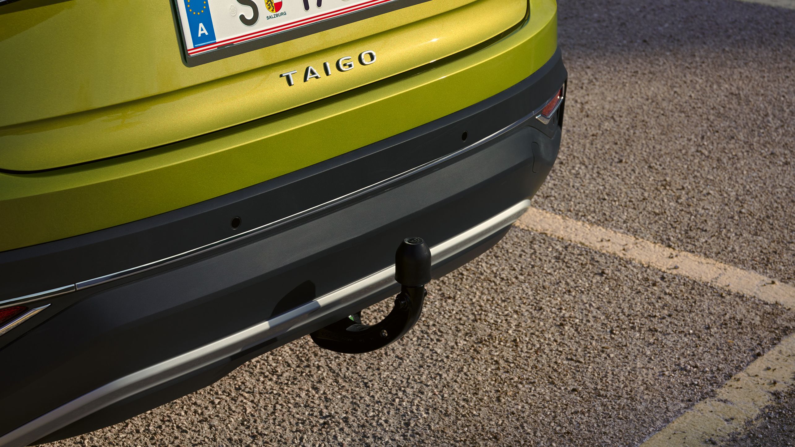Heckansicht eines grünen VW Taigo mit Anhängerkupplung