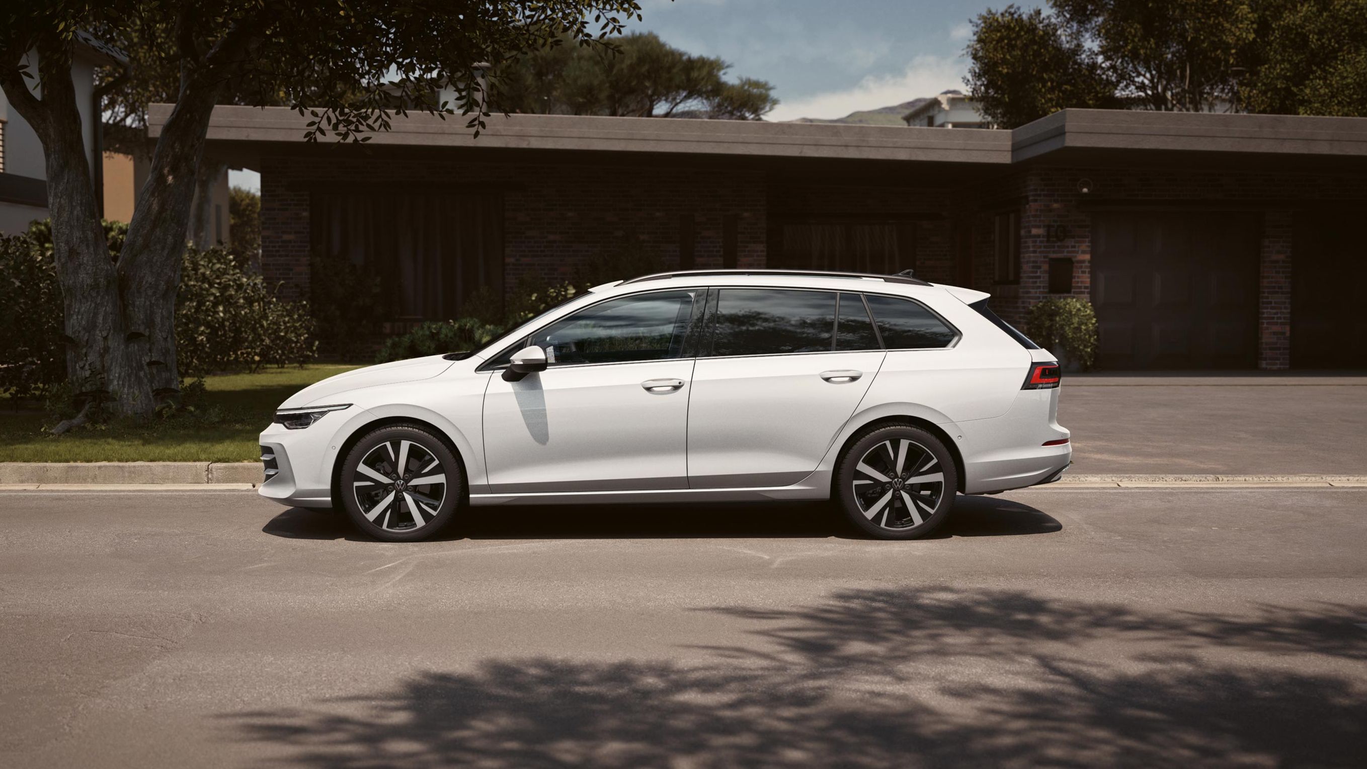 Seitenansicht eines weißen VW Golf Variant geparkt vor Einfamilienhaus