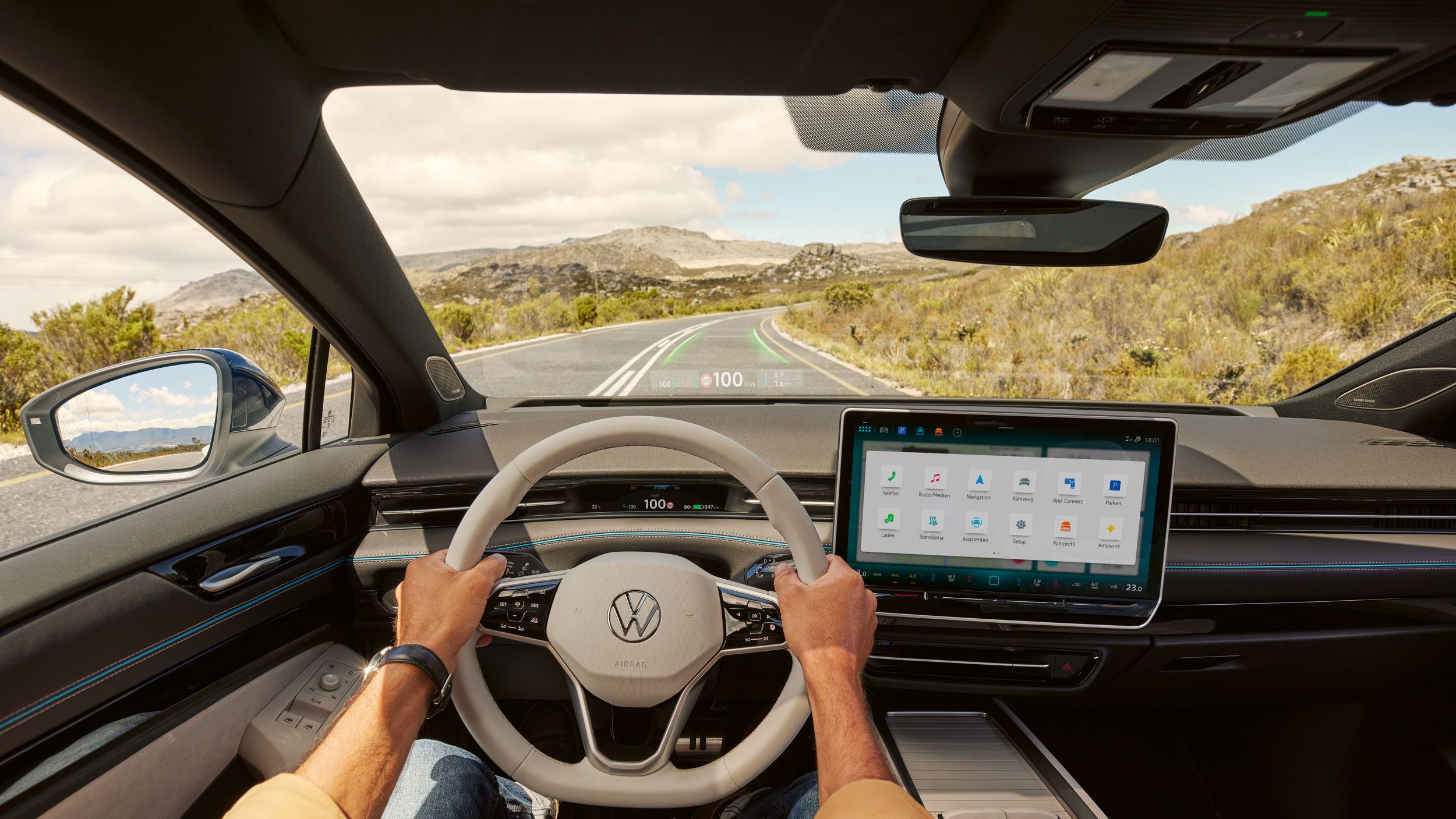 Mann sitzt am Steuer des VW ID.7, in der Windschutzscheibe sieht man die AR-Navigation