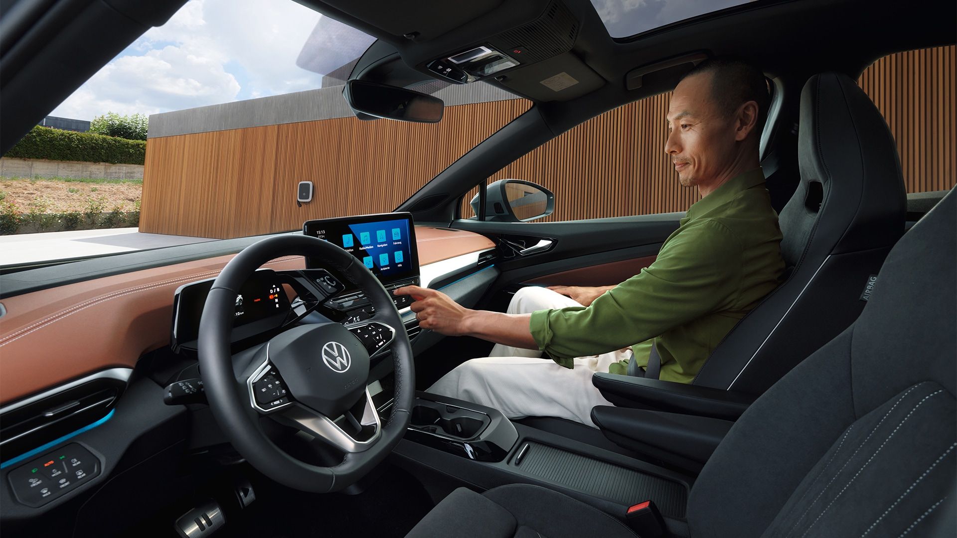 Blick von der Fahrerseite des VW ID.5 auf das Cockpit, ein Mann bedient den Touchscreen