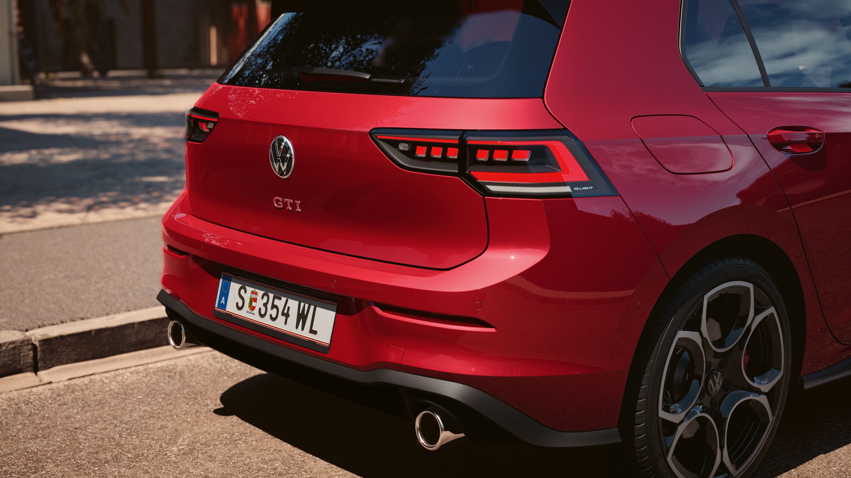 Detailansicht des Hecks eines VW Golf GTI, Fokus auf die IQ.LIGHT LED-Rückleuchten, Logo und Auspuffrohre
