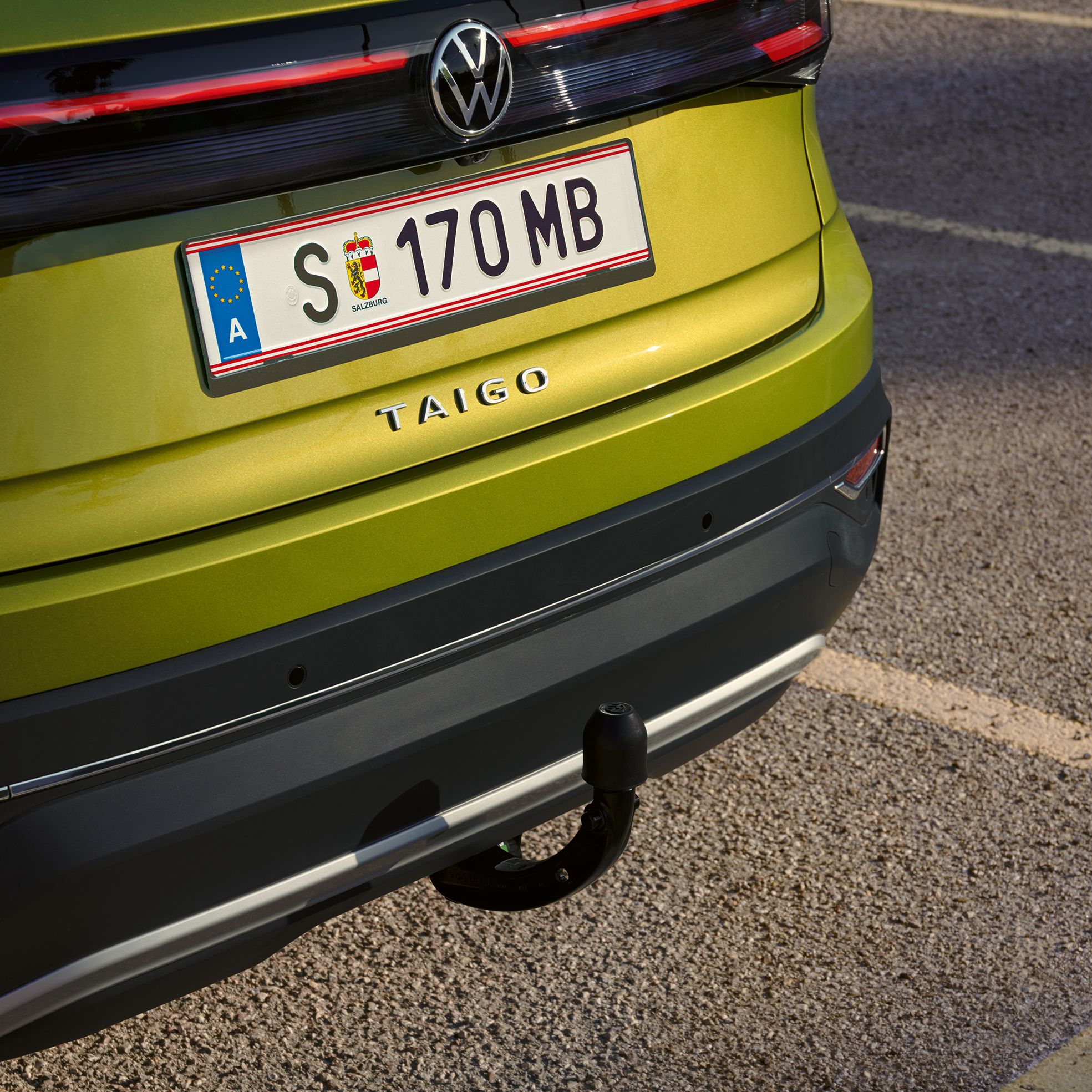 Heckansicht eines grünen VW Taigo mit Anhängerkupplung
