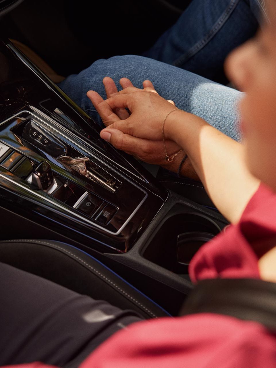 Detailansicht der Mitellkonsole und DSG/Automatikgetriebe im VW Golf, zwei Menschen halten Hände