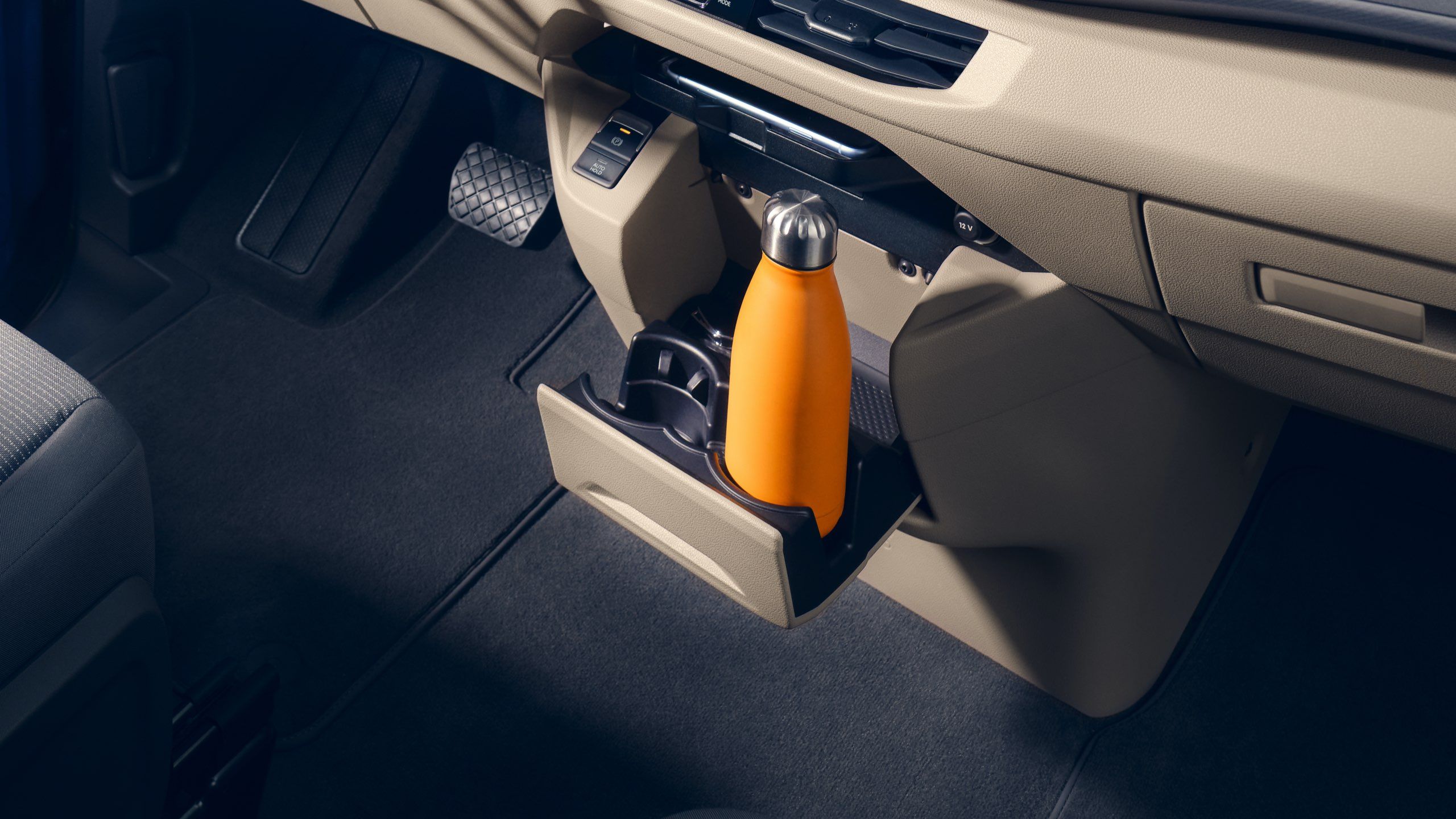 Eine gelbe Flasche steht im Getränkehalter im Fahrerraum des neuen VW Multivan T7 2021.