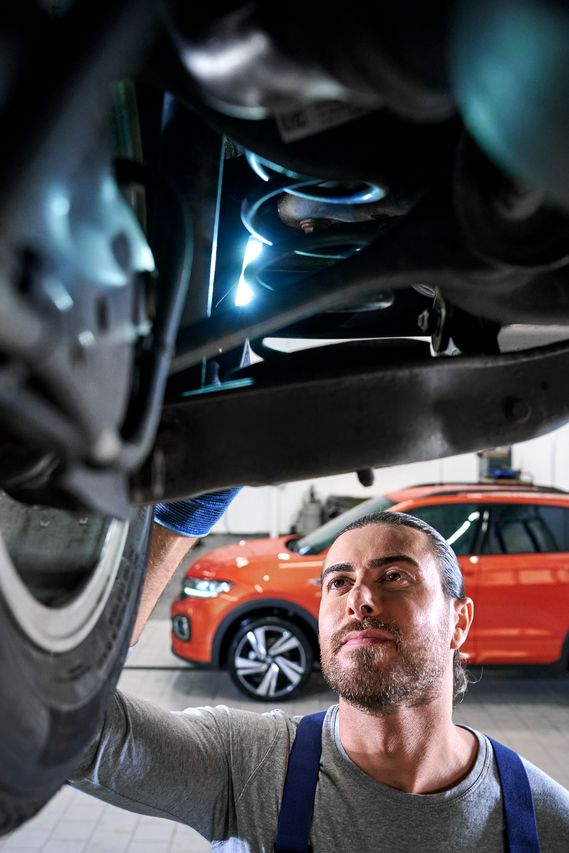 Ein VW Techniker überprüft einen Volkswagen Stoßdämpfer