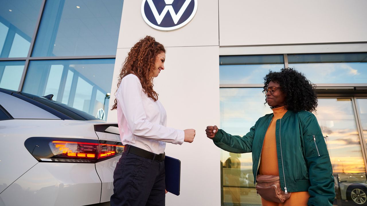 2 Frauen vor einem Volkswagen Autohaus