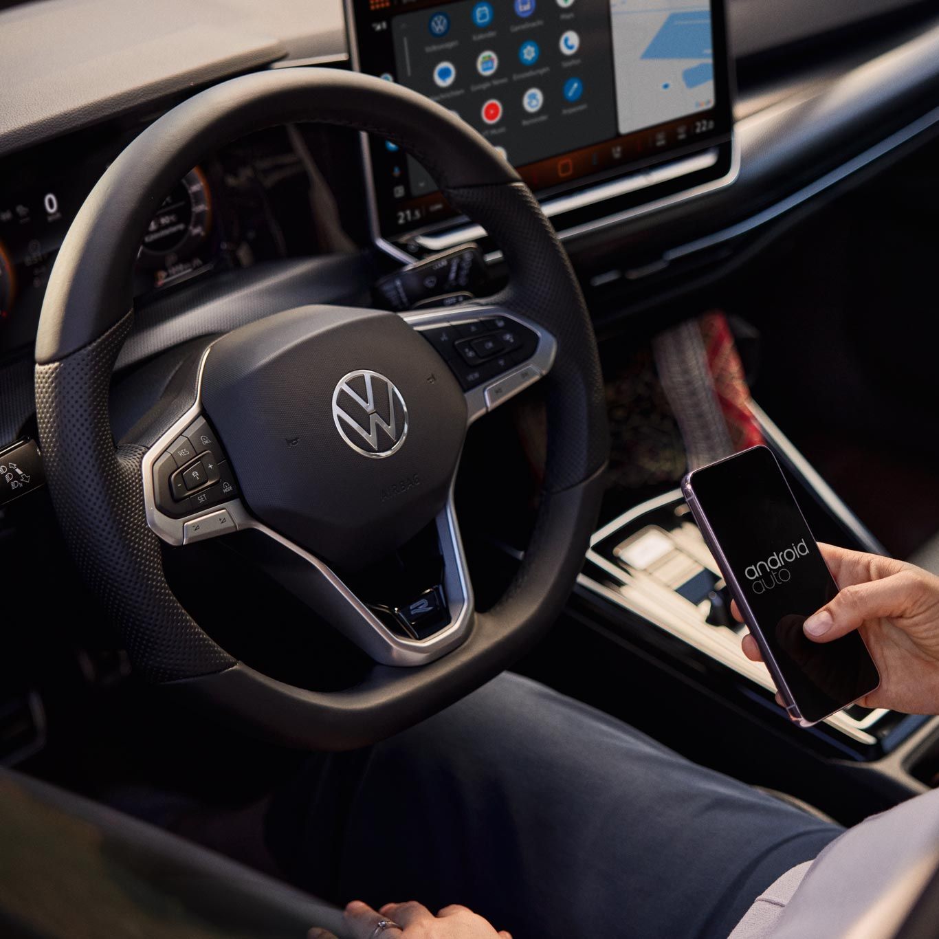 Frau sitzt im VW Golf Variant und nutzt Wireless App-Connect mit ihrem Smartphone