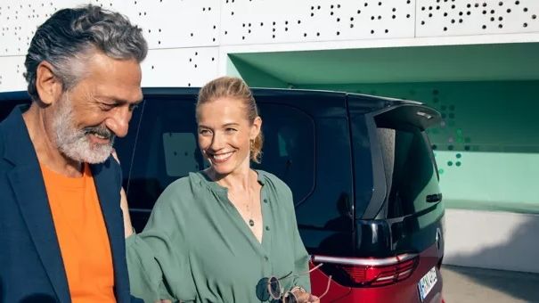 Ein Paar unterhält sich vor einem VW Multivan