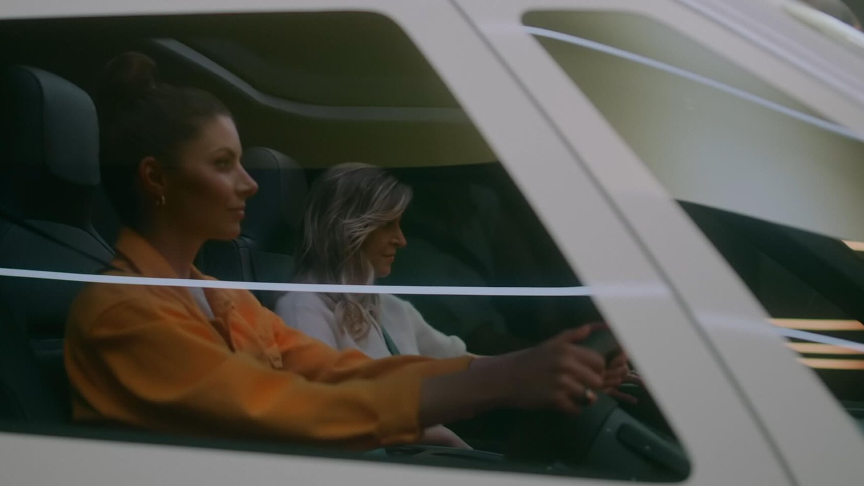 Zwei Frauen fahren mit einem weißen VW ID. Buzz