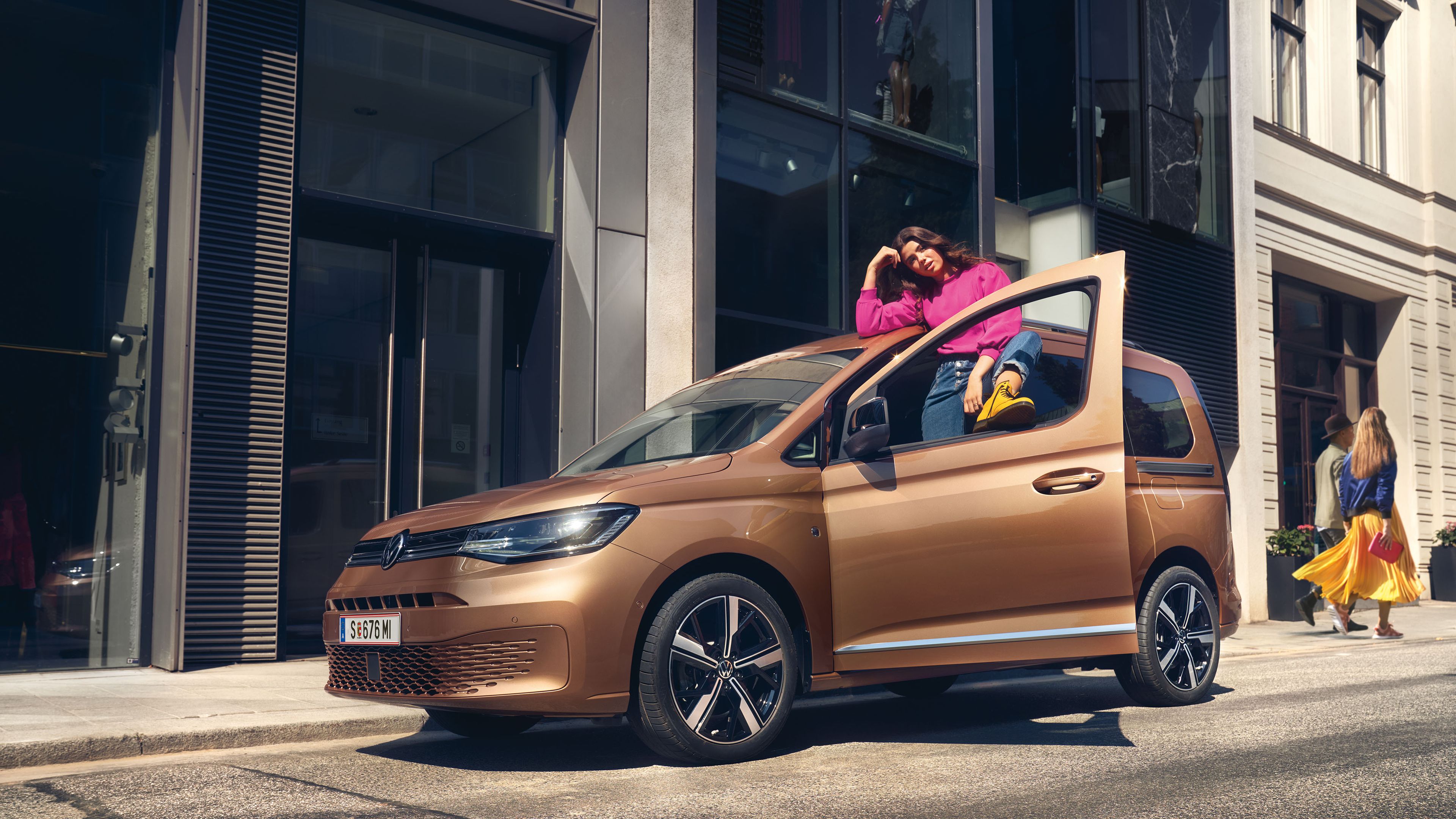 Ein VW Caddy in Copper Bronze steht auf Straße