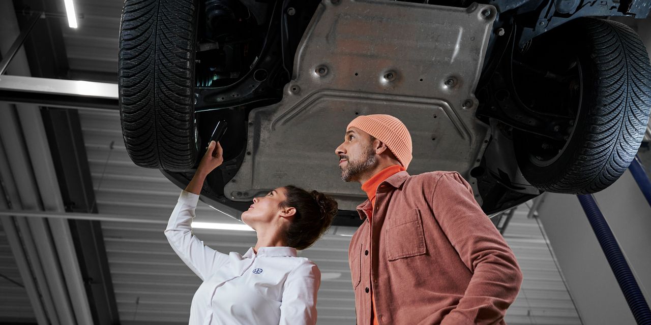 Eine Volkswagen Technikerin bespricht die Reparatur mit einem Kunden