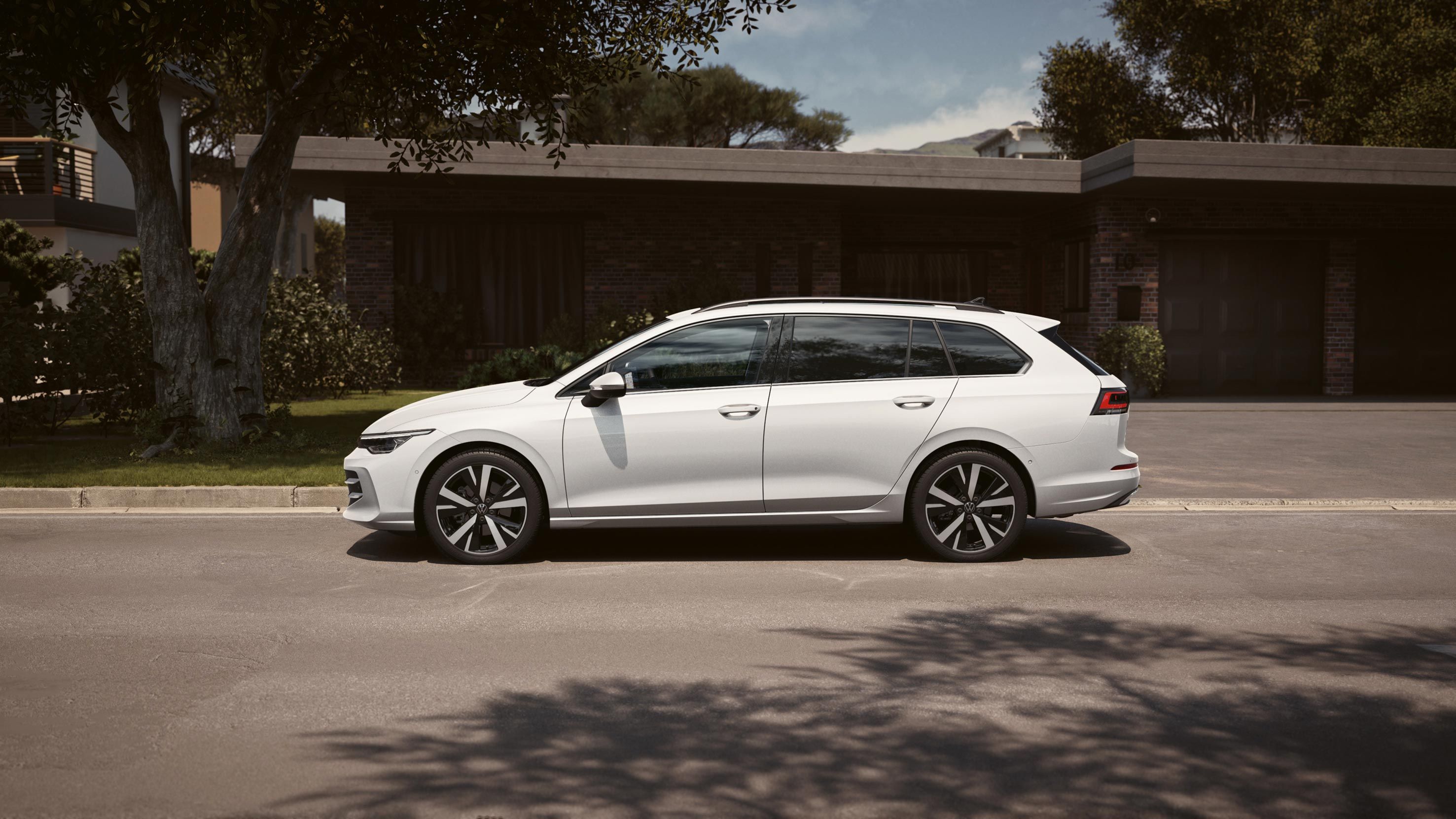 Seitenansicht eines weißen VW Golf Variant geparkt vor Einfamilienhaus