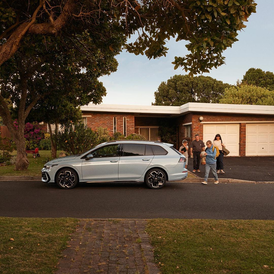 Seitenansicht eines VW Golf Variant in der Farbe Ice Blue Metallic geparkt vor Einfamilienhaus