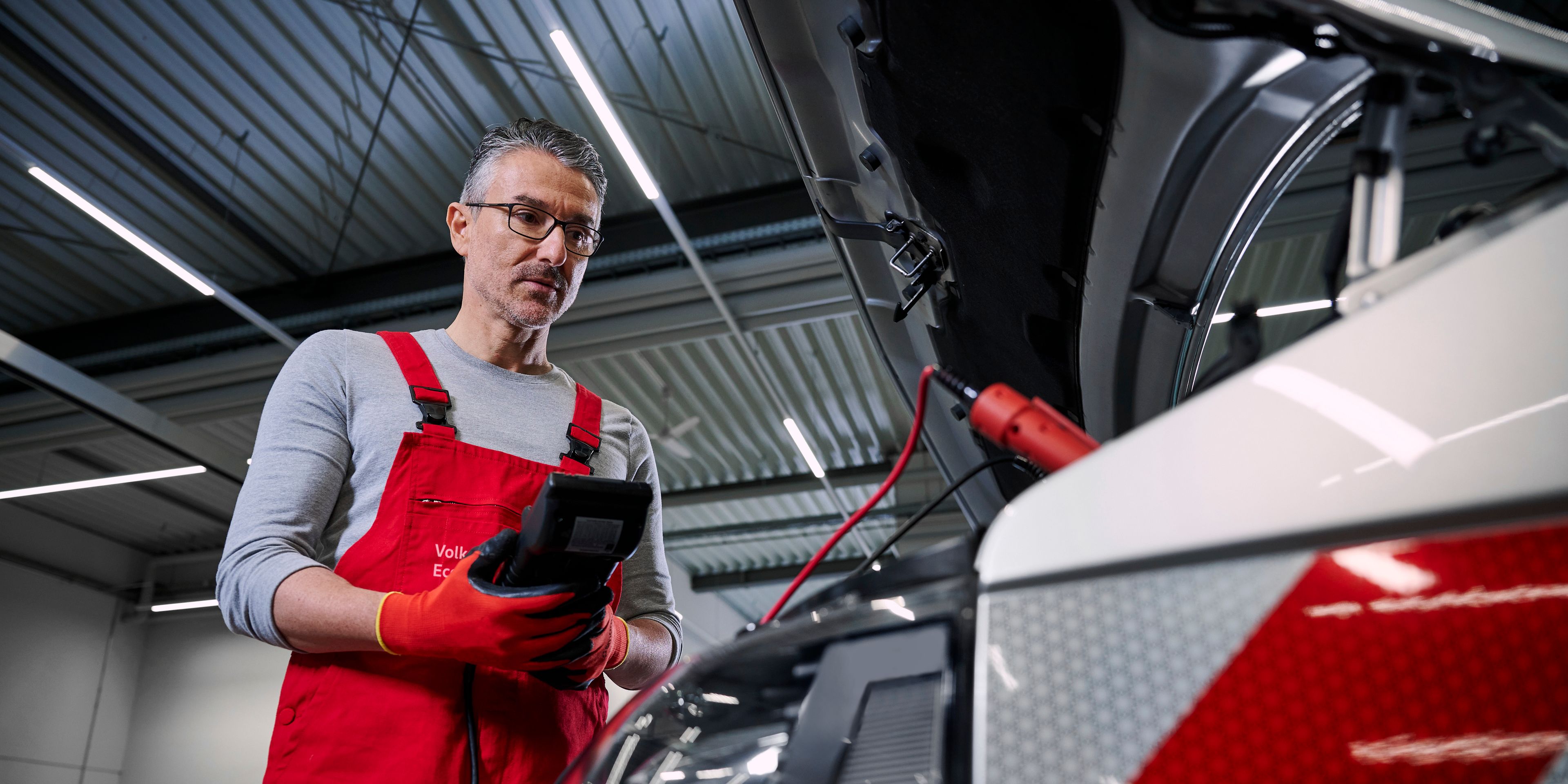 Ein Volkswagen Mechaniker überprüft die Batterien eines Volkswagen