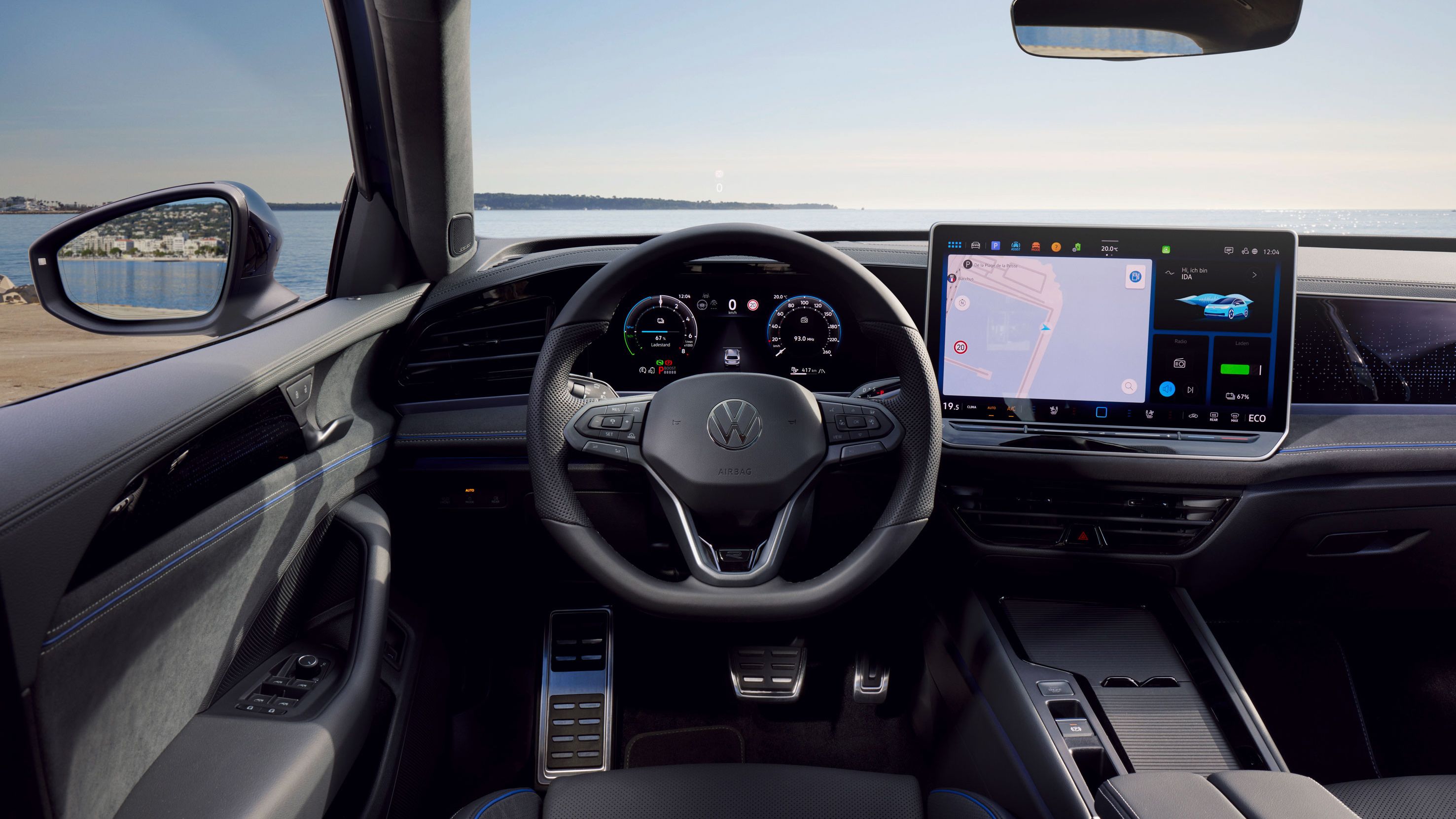Blick durch die Windschutzscheibe des VW Passat mit Digital Cockpit, Multifunktionslenkrad und Infotainmentsystem. 
